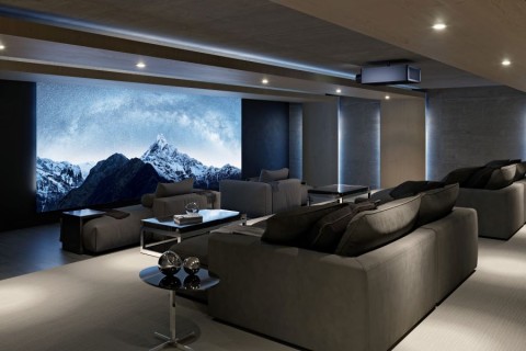 A home movie theater with chaise lounge seating, a large movie screen, and a Sony projector.