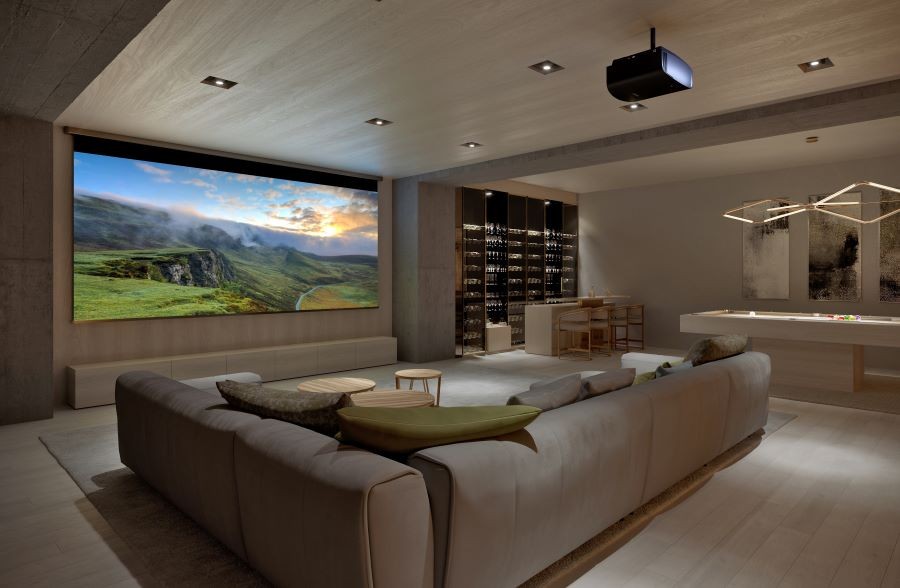 A casual home cinema with a sectional, pool table, large movie screen, and projector.