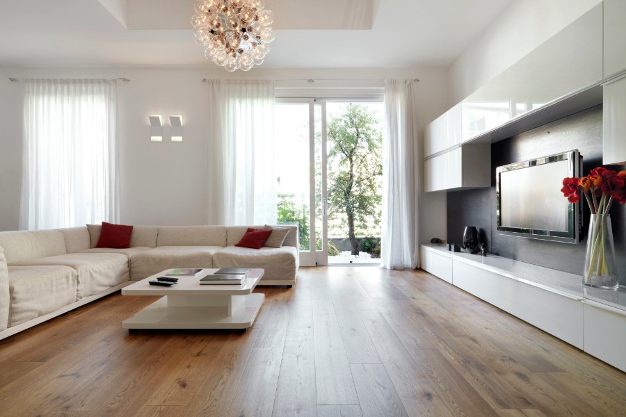  Living room with white furnishings and wooden flooring.