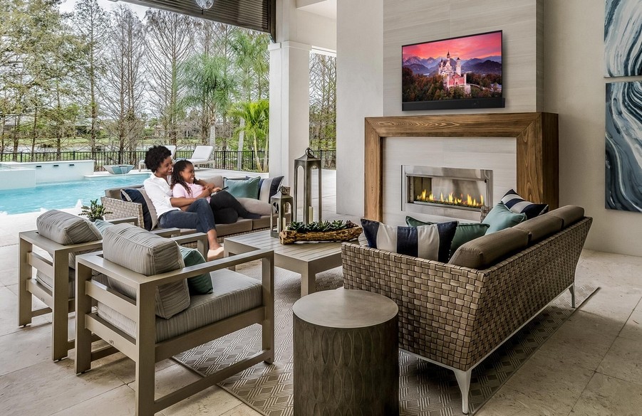 A luxurious outdoor living space with integrated AV and lighting systems seamlessly built into the landscape design.