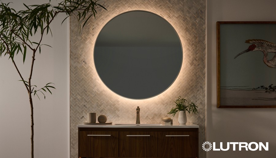 A circular mirror in a home backlit by warm linear lighting.