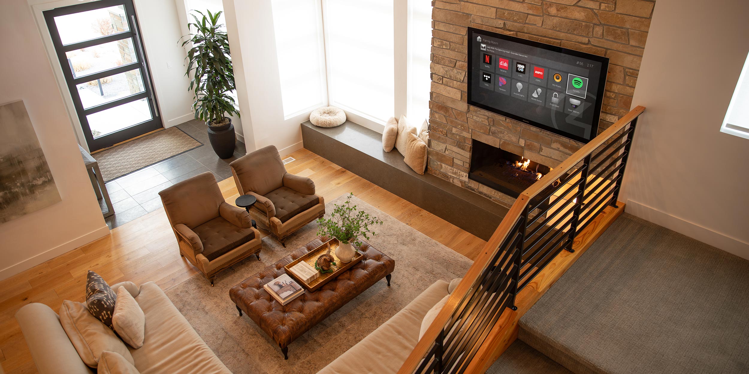 Bright living room with fireplace, wall-mounted TV, and smart home interface
