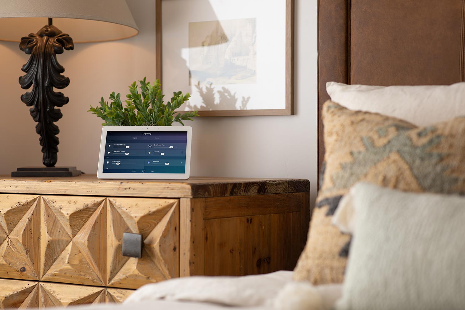 Small touchscreen displaying lighting controls on a nightstand