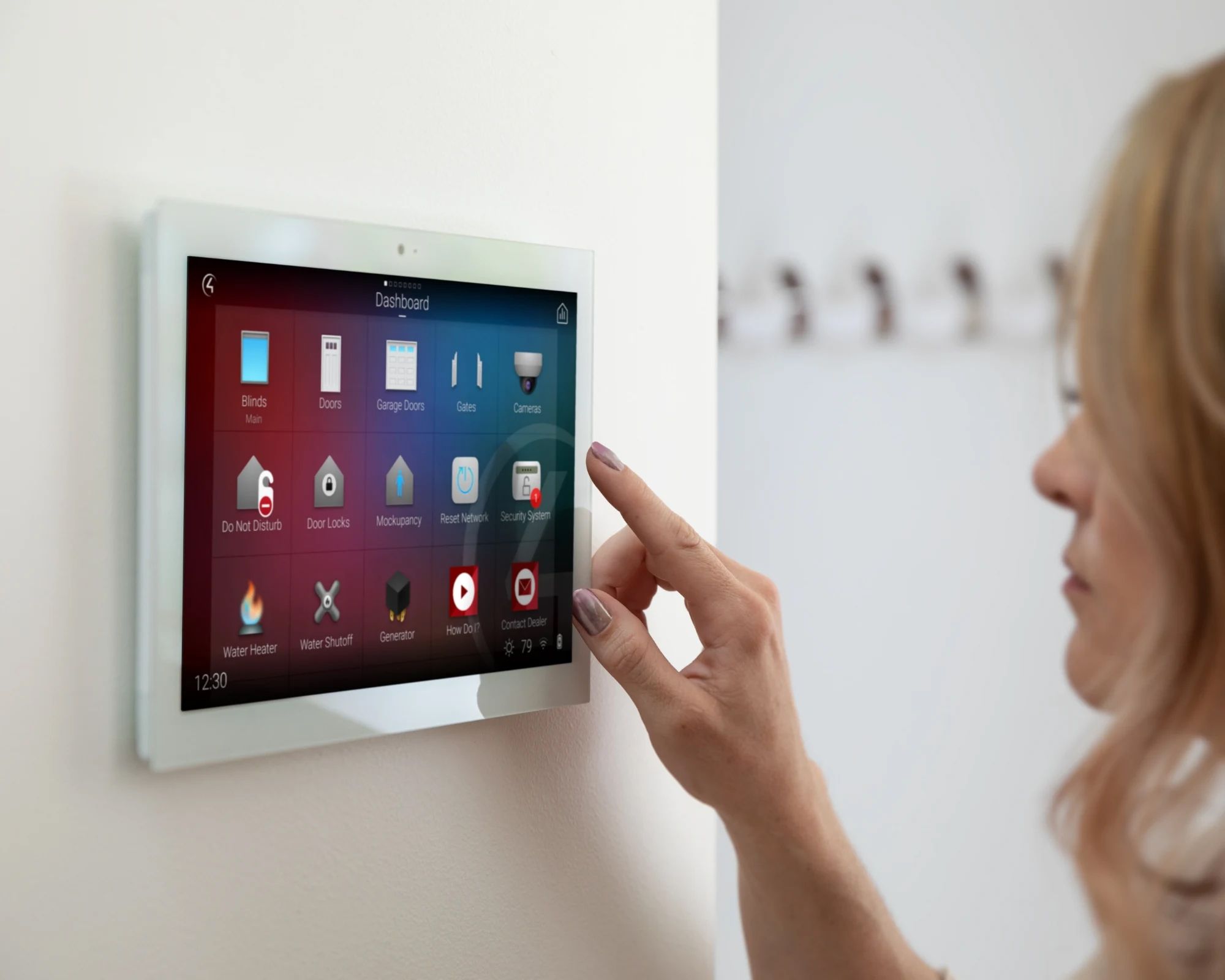 Woman using a wall-mounted touchscreen to control smart home devices